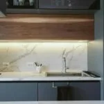 Minimalistyczna kuchnia z marmurowym blatem i stalowym sprzętem AGD