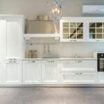 Nowoczesna biała kuchnia z eleganckim żyrandolem