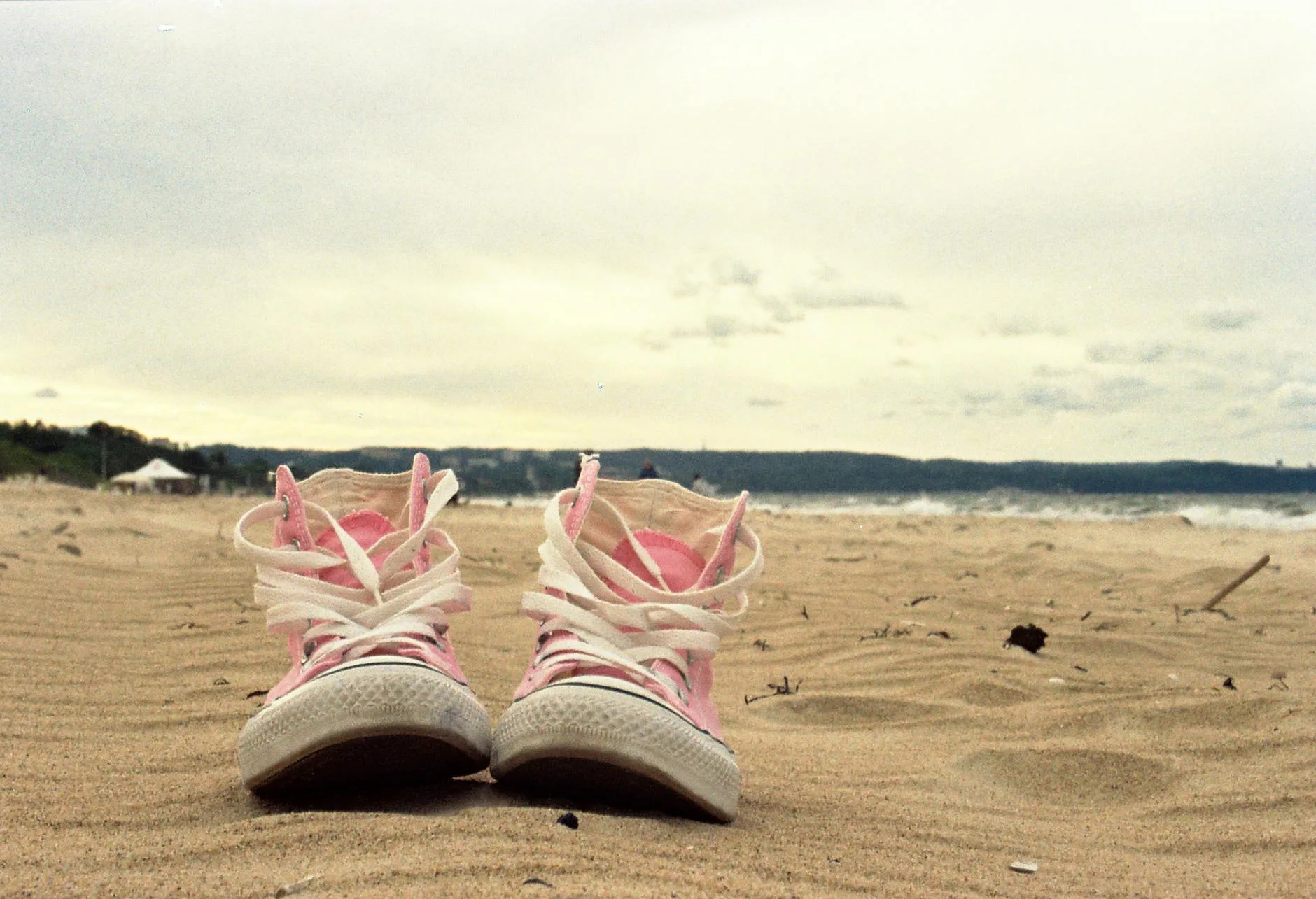 Różowe tenisówki na piaszczystej plaży w Gdańsku o zachodzie słońca