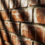 Zbliżenie słonecznej ceglanej ściany z wyraźną, chropowatą fakturą