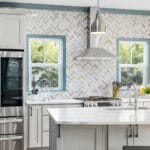 Nowoczesna kuchnia z metalicznymi sprzętami i gładkim blatem roboczym