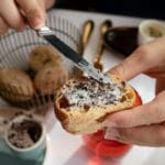 Smarowanie tapenady z czarnych oliwek na pieczywie w kawiarni