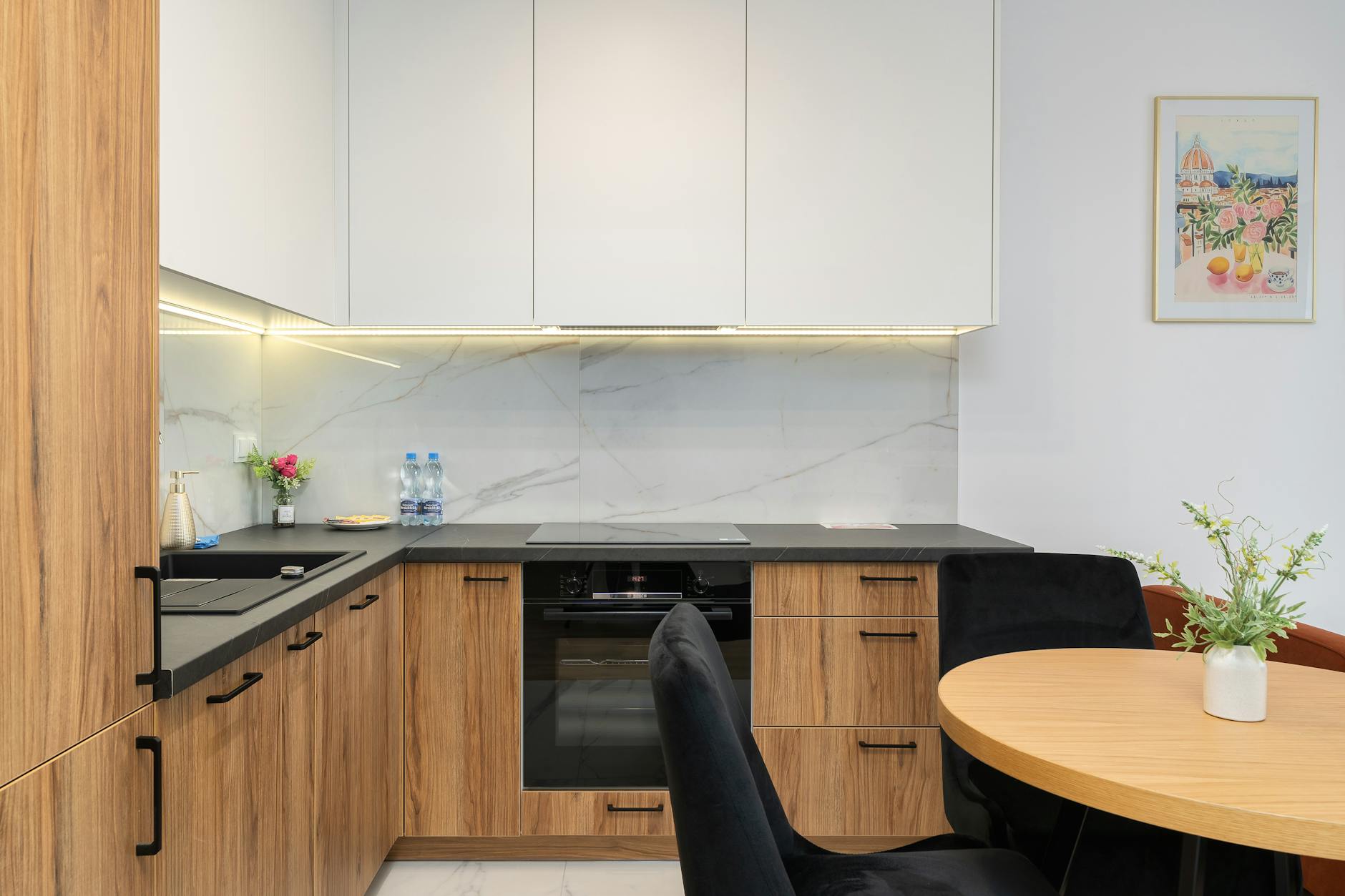 Nowoczesna kuchnia z drewnianymi szafkami, marmurowym tłem i okrągłym stołem