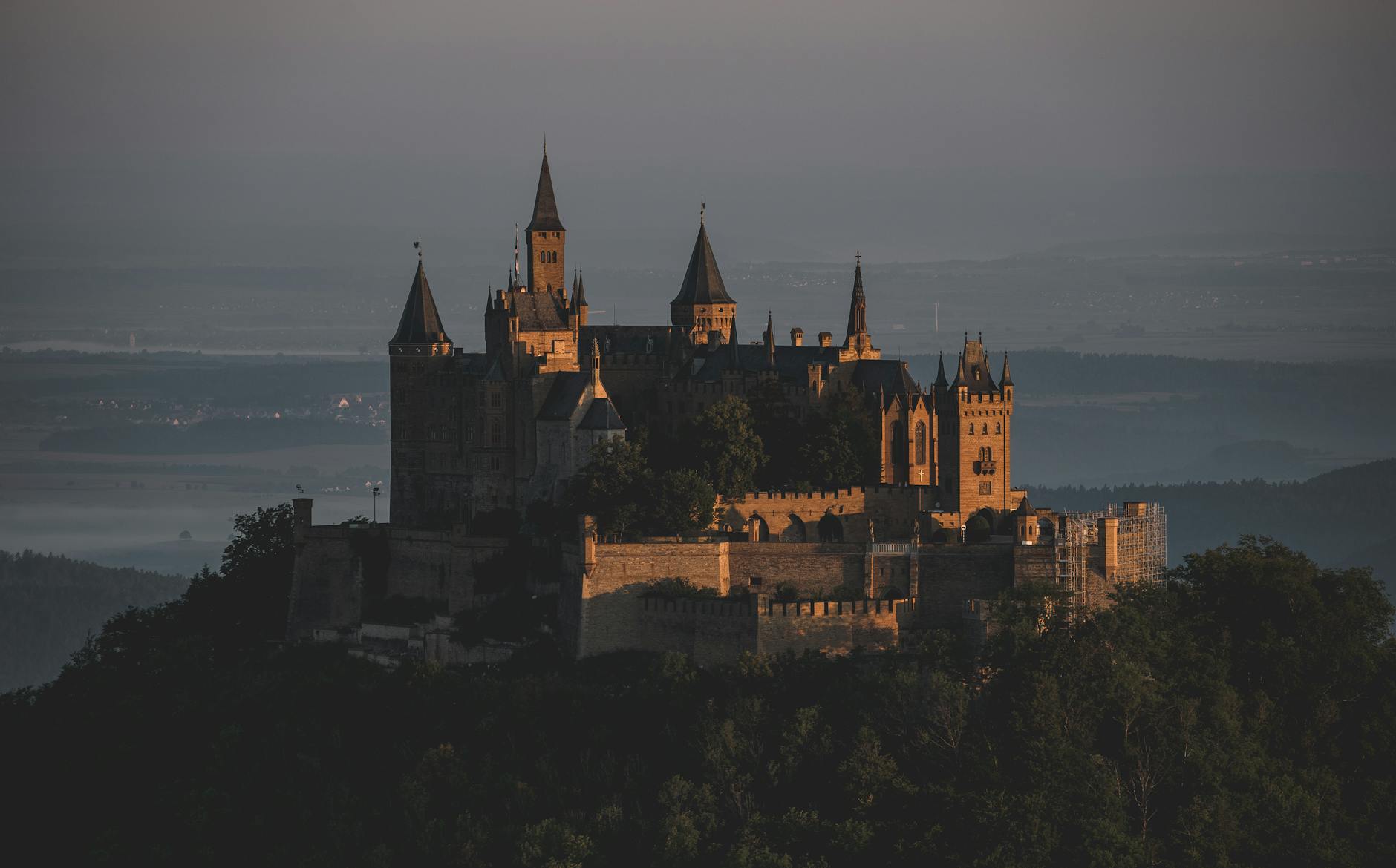 Zamek Hohenzollern o zachodzie słońca wśród zielonych wzgórz